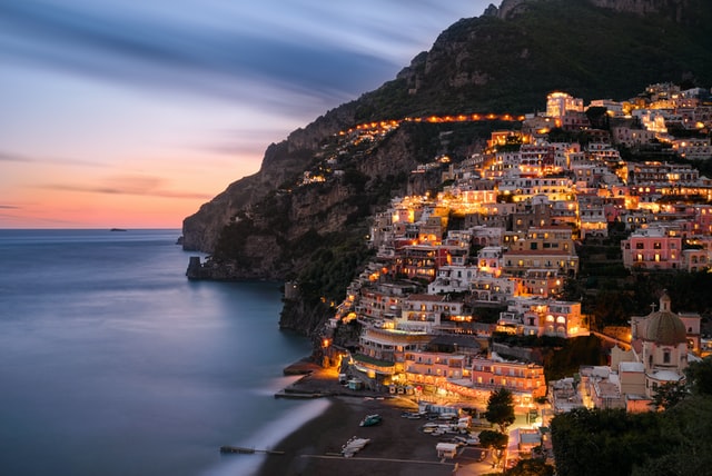 Houses on a mountain during sunset symbolize the ways to explore Italy after moving from the U.S.